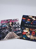 Photo showing Barbie Bazaar magazine and Bob Mackie gemstone book laid side by side with visible front covers.