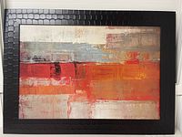 Full view of the framed abstract artwork showing the geometric textured dark brown frame and the colorful abstract painting inside.