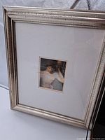 Framed print showing the entire silver frame with glass and white mat border, center image of dancer small in size.