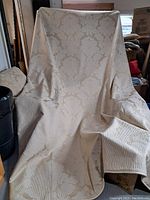 Photo showing the large tapestry draped over a chair, displaying the front damask floral pattern and large size.