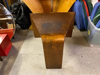 Side view of vintage solid wood side table showing curved design and wear marks on surface.