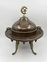 Full view of the vintage copper and brass brazier showing lid, handles, and legs.