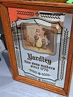 Front view of framed Yardley glass mirror soap making sign with decorative gold and black accents and vintage illustration