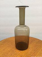 Front view of the Holmegaard bottle vase showing its full height and body shape on a wooden surface against a white backdrop.