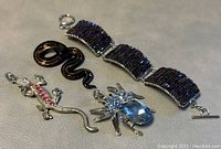 Lot contents showing the Murano glass snake pendant and the multicolored beaded bracelet.