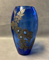 Full view of the blue glass vase with silver floral overlay design and blue accents, showing floral pattern detail.