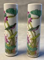 Front view of two matching Chinese porcelain bud vases showing hand-painted lotus leaves, flowers, and birds.