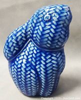 Front angled view of the blue and white ceramic bunny figurine showing textured leaf-like pattern and glossy finish.