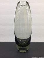 Front view of the tall, sleek smoke glass vase with thick base and smooth finish, against plain background.