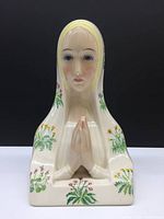 Front view of the Lenci ceramic bust depicting the Virgin Mary with hands in prayer and hand painted floral decoration on veil