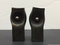 Front view of both metal candle holders showing concave center and spike for candle.