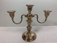 Front view of entire three-arm candelabra showing central riser and base