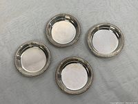 Overhead shot of four round miniature bowls arranged on cloth background