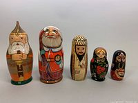 All five sets of nesting dolls arranged in a row showing variation in size and design.