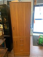 Front view of wardrobe showing door, drawers, recessed pulls and overall finish