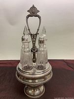 Full view of silver plated caddy holding four crystal vessels