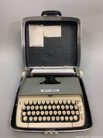Front view of vintage Smith-Corona SCM Galaxie electric typewriter open in case, showing keyboard and brand logo.