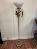 Full view of the vintage torchiere floor lamp showing the milk glass shade and the three candle-like bulbs beneath it.