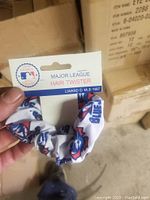 Close-up photo of a white fabric hair twister scrunchie with Blue Jays logos in blue and red, attached to branded cardboard tag with Major League Baseball and MLB 1997 markings.