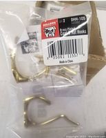 Packaged brass plated coat and hat hooks with screws, label showing Bulldog brand and model DHH-105, barcode, and 'Made in China' marking.