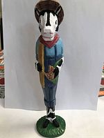 Front view of the colorful badger wood carving with detailed painted features and accessories
