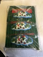 Front view of pack of six Christmas-themed hair clips in sealed packaging showing multiple clips with colorful 3D holiday figures.