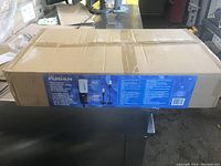 Cardboard box packaging for Fusion touchless automatic hand sanitizer dispenser with stand, blue product label visible.