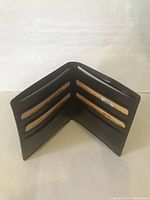 Brown leather wallet open showing the 10 card slots and bill compartment