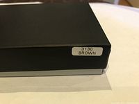 Black presentation box with a label that reads 3130 BROWN, indicating model and color of the wallet inside.