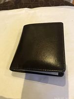 Closed brown leather wallet showing smooth finish and compact size.