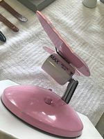 Side view of pink light fixture base with attached butterfly wings and bulb holder.