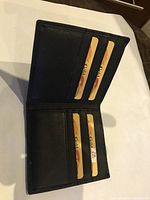 Open wallet showing 8 visible card slots with placeholder cards inserted, showing leather texture and stitching.