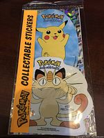 Front of sealed 1999 Pokemon collectible sticker pack showing Pikachu and Meowth artwork with original branding and text.
