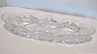 Side angle of the crystal relish dish showcasing the scalloped edge and deep cut designs