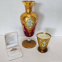 Front angle showing the hand-painted antique art glass vase, matching smaller glass cup, and engagement ring in Fran's Jewelers box.