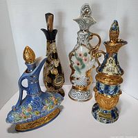 Four vintage ceramic Jim Beam decanters arranged on white backdrop, showing front view with visible details and stoppers