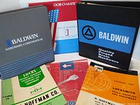Five vintage hardware and locksmith manuals spread showing binder covers and catalog covers