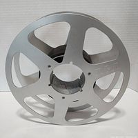 Front view of the vintage RCA metal take up reel showing the RCA logo on the silver metal surface.