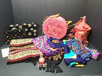 Group photo showing all 13 pieces of beaded bags, silk scarves, tapestry and woven purses, and other feminine accessories arranged on a black backdrop.
