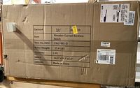 Photo of the unopened cardboard box containing the wooden curved backless bench with shipping labels and product details.