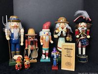 Full lot view showing all ten nutcracker figures of various sizes and styles including farmer with pig, Santa, magician, drum major, and smaller figures.