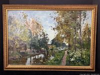 Frontal view of framed oil painting showing landscape with canal, trees and distant windmill