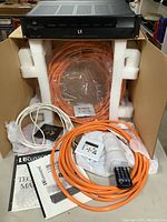 Front view of controller in box with cables and accessories