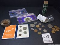 Full lot overview showing the coin collections, coin bank, booklet, and assorted loose coins and tokens