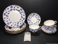 Full view of all 12 pieces in the tea set including 6 dessert plates, 3 tea cups, and 3 saucers arranged for display