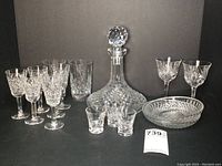 Full lot view showing all the crystal glassware items including decanter, tumblers, glasses, dishes.