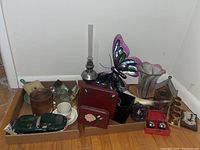Full lot overview showing all items including oil lamp, butterfly decoration, model car, napkin holder, candle holders, glass ornament, vase, and metal birdhouse.