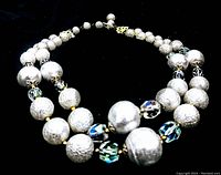 Close-up image of the double strand vintage necklace showing textured silver-tone round beads and faceted crystal beads.