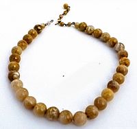 Full view of the Baltic amber necklace laid flat showing shape, bead size, and color variations.