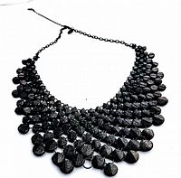 Front and side views of the vintage lava rock bib necklace showing layered lava rock beads and black metal chain.